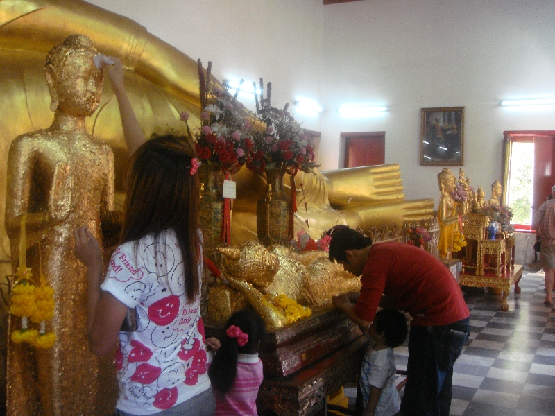 Thai family paying respect to the Buddha, Nakhon Pathom Thailand